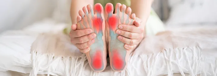 Chiropractic Stratford CT Foot Pain Person on a bed holding their feet.